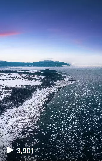 an aerial view of a large body of water with Ice and snow