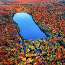 Magical Fall colours from above around a blue water lake in Canada