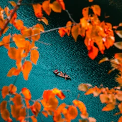 Canoe in a river with fall leaves as a frame