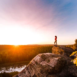 Girl on the edge of a cliff and sunset at Eagles nest in Ottawa