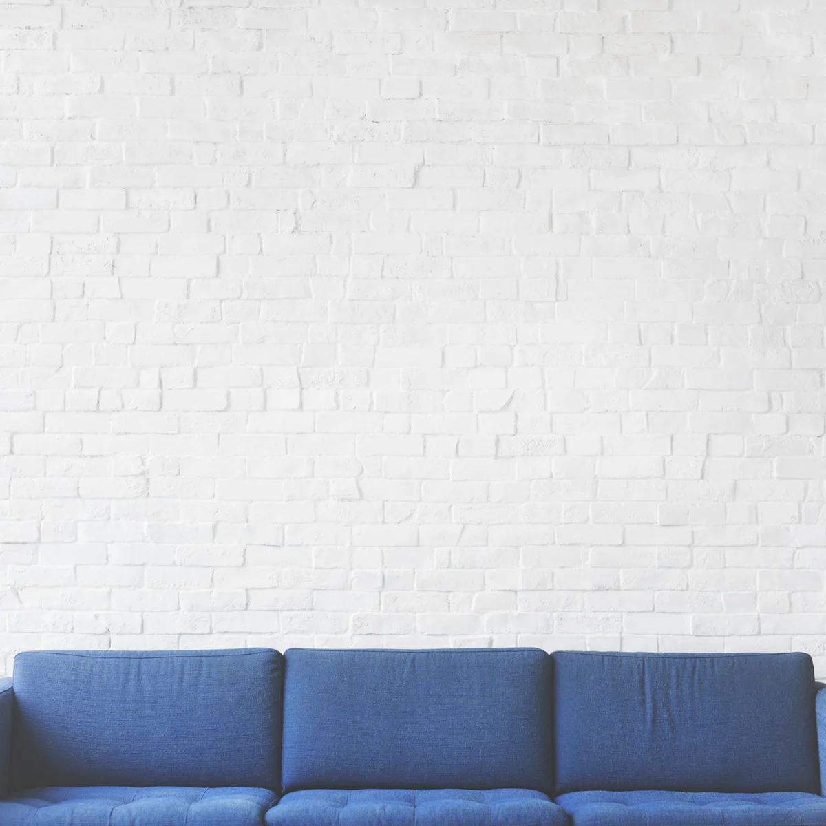 Living room wall with a comfy couch and brick wall